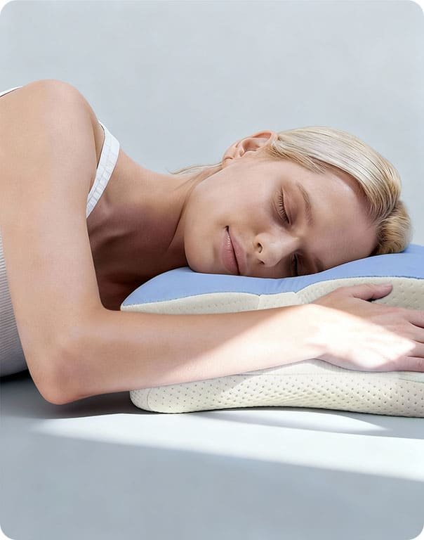 Woman sleeping on her stomach with her arm resting on the Ergo Pillow